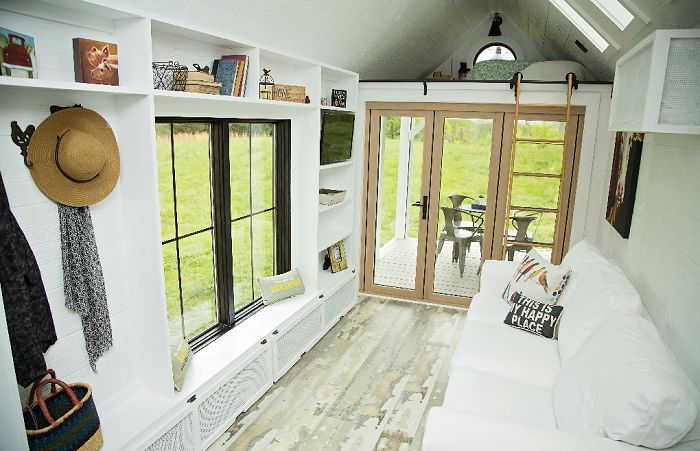 Salon lumineux d'une mini maison avec terrasse © Perch and Nest