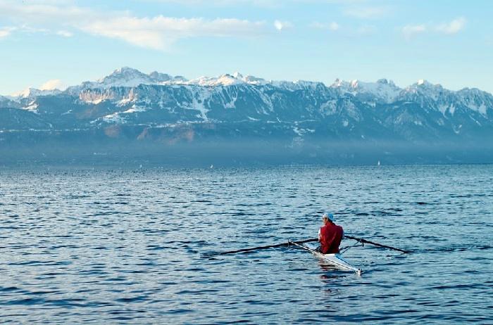 Pratique de l'aviron sur le lac léman avec une vue sur les Alpes françaises © DR