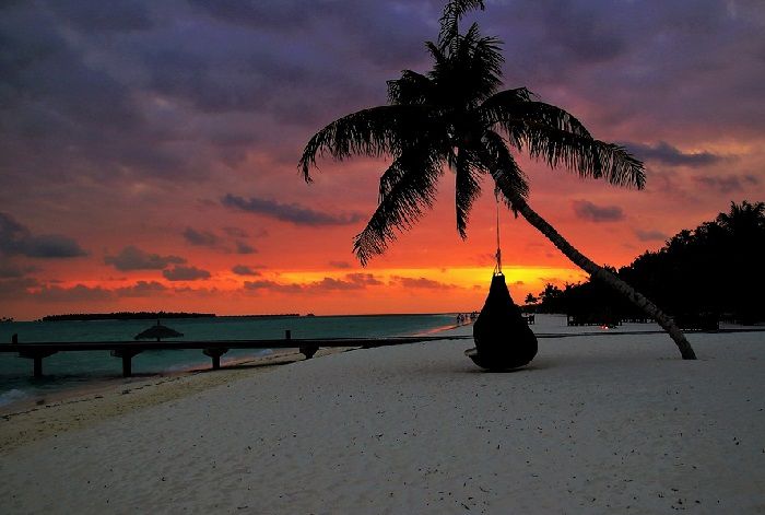 Optez pour une location de villa avec piscine aux Maldives et profitez d'une balade sur la plage à la tombée de la nuit