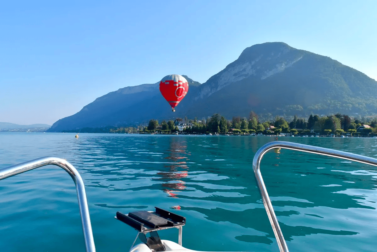 Vue sur une montgolfière survolant le lac d'Annecy © Carnet des geekeries