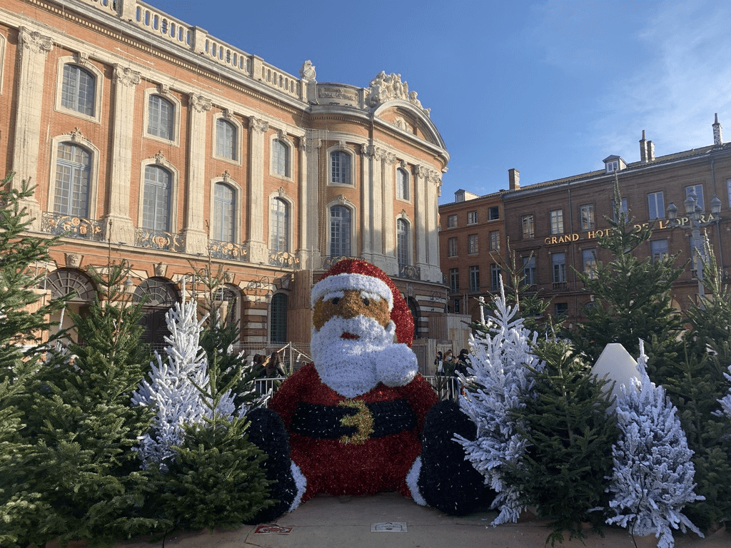 Le père Noël entouré de sapins Place du Capitole © Marché de Noël de Toulouse